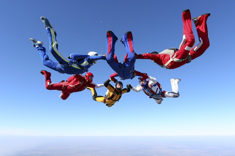 Спортсмени стрибають з парашутом і летять в небі